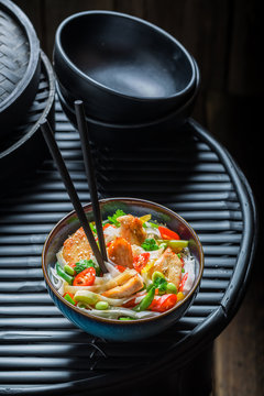 Spicy noodle in dark bowl with chopsticks