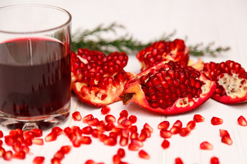 A glass of pomegranate juice and pomegranate seeds