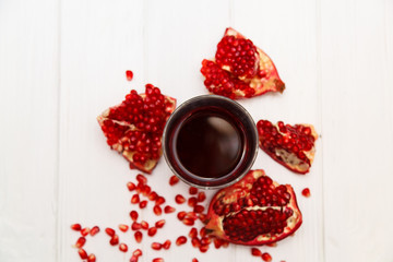 A glass of pomegranate juice and pomegranate seeds