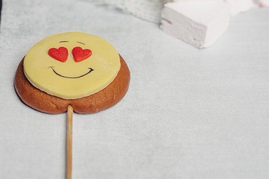 cookie smiley on a stick with hearts instead of eyes