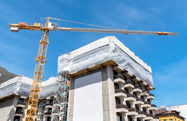 Fototapeta premium Crane and building construction site against blue sky
