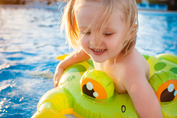 Cute happy little girl having fun in swimming pool