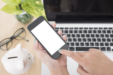 Business hand holding smart phone with white screen isolated on desk office background.