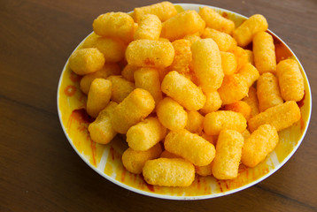 Corn sticks in bowl on wooden table