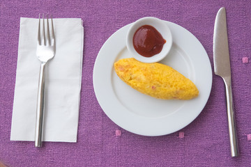 Hot omelet with tomato sauce in white dish