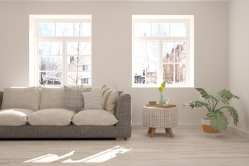Modern interior design with sofa and winter landscape in window