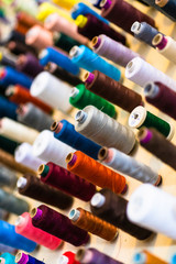Sewing thread on bobbins in tailor shop