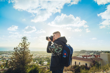 Traveler photographer with digital camera on top of the mountain.