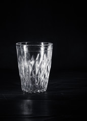 Transparent glass cup. Black background.