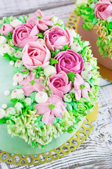 Two celebratory cake with flowers rose on a white wooden background