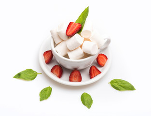 cup with marshmallow on plate with basil, strawberry