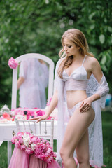 beautiful young woman in nightgown standing near dressing table