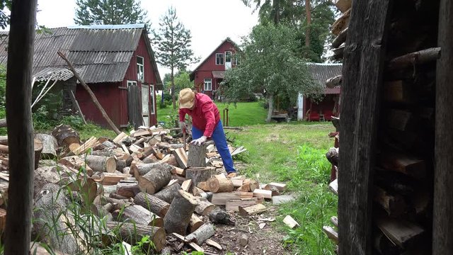 cottager split hard log in country woodshed in summertime. 4K 