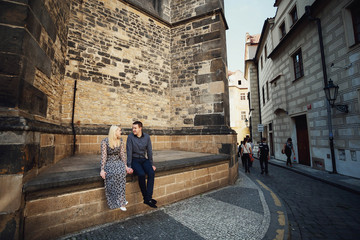 Fototapeta na wymiar beautiful and young woman and man sitting near brick wall
