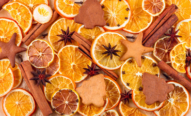 Dried slices of oranges, lemons, star anise, cinnamon sticks and gingerbreads on beige background, Christmas background