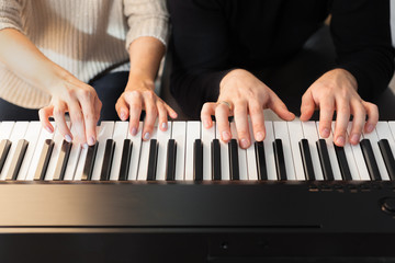 Obraz premium Closeup of hands playing piano. Music and hobby concept