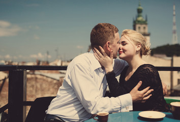 The lovely couple in love kissing near table