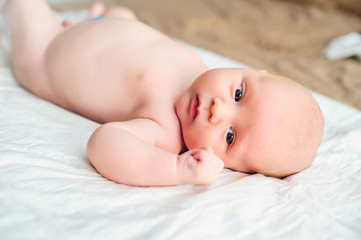 infant lying on bed