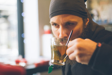 Handsome young man enjoying tea in a restaurant