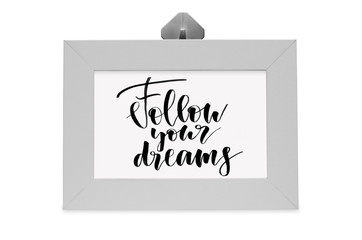 Follow your dreams. Handwritten text. White photo frame. Modern calligraphy.