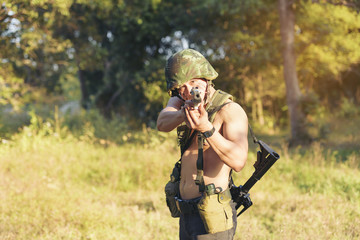 Portrait of man aiming with rifle while standing in forest