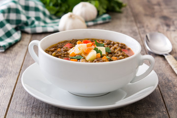Lentil soup in a bowl on wooden background
