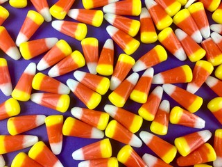 Candy corn on a purple surface filling the frame