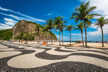 Berühmtes Mosaik aus Bürgersteig und Palmen in Leme und am Strand von Copacabana in Rio de Janeiro, Brasilien