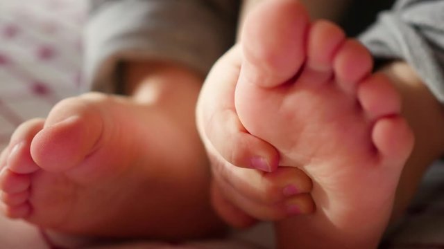 children's small hands close-up holding little feet . gentle touch