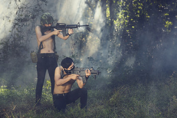 Men aiming with rifle in forest - 137088913