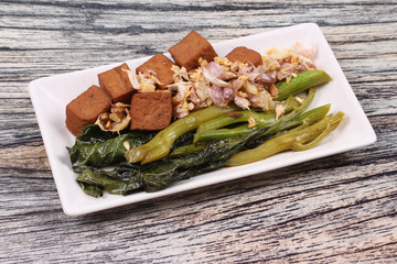 Fried kale with tofu in brown soup.