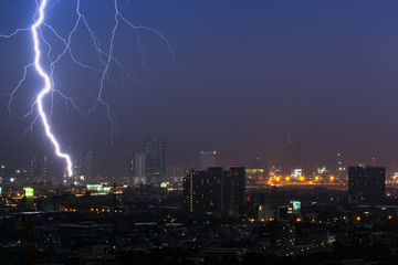 Naklejka na ściany i meble Dramatic thunder storm lightning bolt on the horizontal sky and city scape