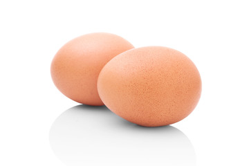 Two brown chicken eggs isolated on white background with shadow reflection. Brown chicken eggs on white background with shadow reflection. Eggs on reflective underlay. Whole eggs on white background.
