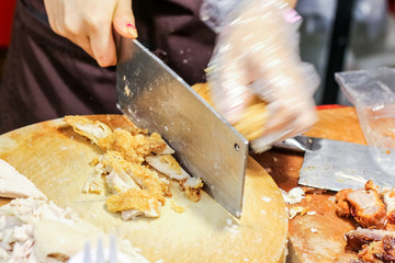 People used knife to chopped chicken for hainan chicken rice