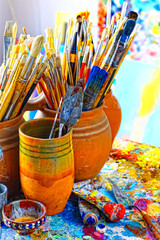 Paint brushes in the cup and palette paints