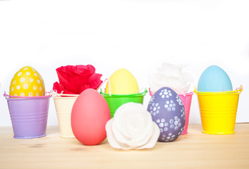 Easter colored eggs in colorful buckets and paper flowers