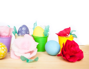 Easter colored eggs in colorful buckets and paper flowers