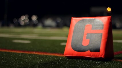 Dolly of a football field at night with a goal line G in the foreground.