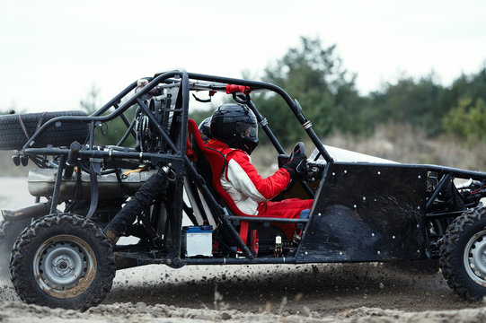 Sports car racing on the track. The driver behind the wheel of a buggy with a second driver