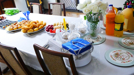 The chairs and table for guests, decorated with candles, served with cutlery and crockery and covered with a cloth.