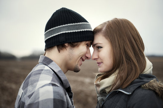 Teenage girl (16-17) face to face with her boyfriend in field