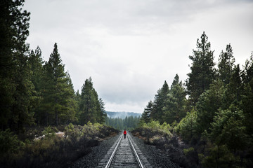 Woman walking on railroad tracks