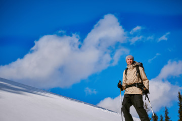 hiker with backpack on the trail in the Carpathians mountains at winter. picture of hiker taken on wide angle from low point