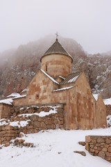 Armenian monastery Noravank - world`s wonder erected in the 13th century. Mysterious winter panorama. The whole monastery covered with fog