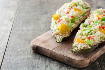 Stuffed eggplant with quinoa and vegetables on wooden background
