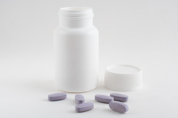 Medicine bottle with pills on white background