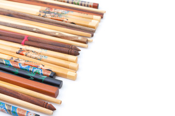 Obraz premium Many wooden chopsticks isolated on white background. Decorative wooden chopsticks background. Many chopsticks corner. Chopsticks distributed on white background. Chopsticks heap. Lot of chopsticks.