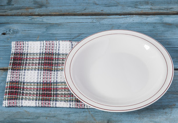 Empty plate with napkin on blue wooden table