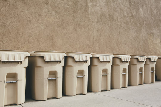 Row of recycling containers along sidewalk and street