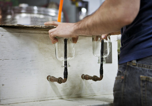 Distillery worker cleaning bottles